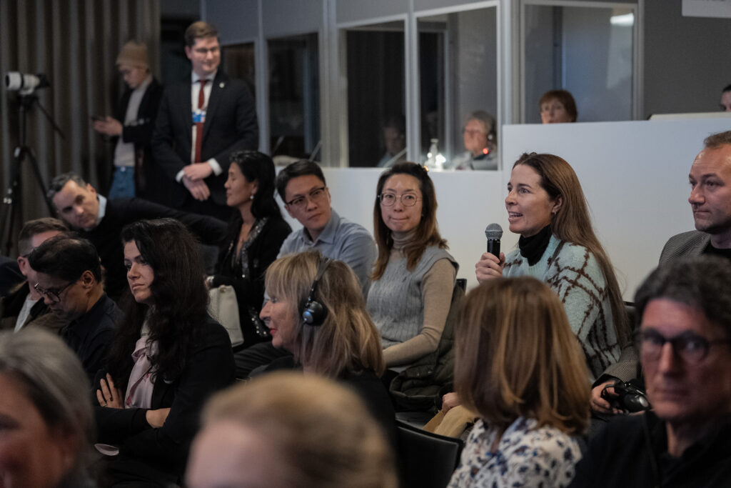 Aktives Publikum beim WEF: sitzende Frau stellt eine Frage, aufmerksame Zuhörer*innen
